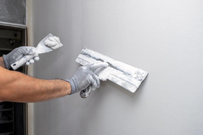 Mann-bereitet-Wand-fuer-Fliesen-vor