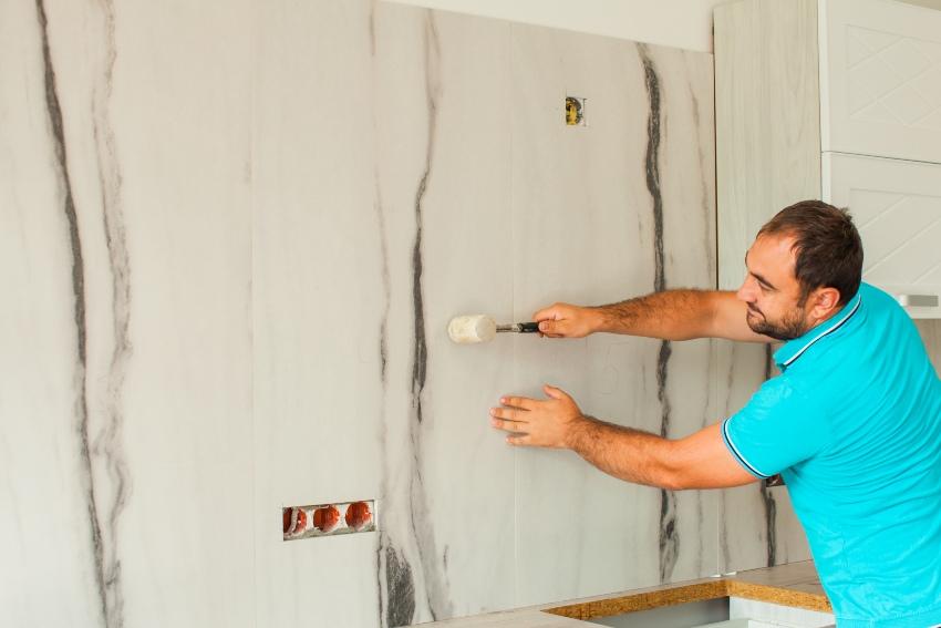 Mit der Klopfprobe lassen sich Problemstellen identifizieren Klopftest-an-Wand-mit-Gummihammer - Fliesenuntergrund vorbereiten